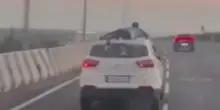 India, poliziotti si aggrappa sull'auto in fuga