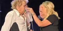 Rod Stewart soccorso con la maschera per l'ossigeno a un concerto
