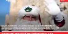 Gerusalemme, uomo vestito da Babbo Natale regala alberi
