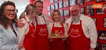 Meloni mangia la pizza da PizzAut durante la visita al ristorante a Monza per il Primo Maggio
