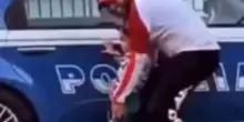 Fa orinare il figlio sull'auto della polizia, il video che indigna: "Remigrazione"
