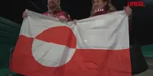 Olimpiadi 2026, due tifosi lettoni sventolano la bandiera della Groenlandia alla partita di hockey
