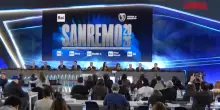 Sanremo 2026, Conti consegna i fiori a Laura Pausini al tavolo in conferenza stampa
