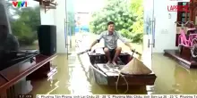 Vietnam, case sommerse a causa delle inondazioni: un uomo entra in salotto con la canoa