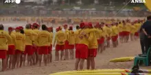 L&rsquo;omaggio dei bagnini australiani per le vittime di Bondi Beach: decine di soccorritori schierati lungo la riva &ndash; Video