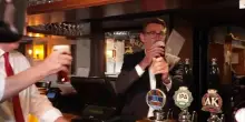 Andy Burnham festeggia il taglio delle tasse al pub con birra in mano