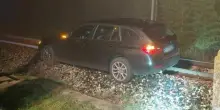 Automobilista sbaglia strada nella nebbia al passaggio a livello e finisce con la Bmw sui binari del treno