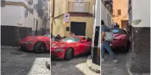 Resta bloccato con la Ferrari tra le vie del centro storico e viene aiutato dai passanti liberare l'auto di lusso