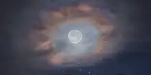 Un'aureola di nuvole per la Luna sopra le cime delle Dolomiti
