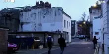 Due bambini sdraiati a terra che guardano il cielo, il nuovo murale di Banksy a Londra