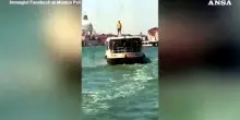 In piedi sopra un vaporetto, bravata nel centro di Venezia