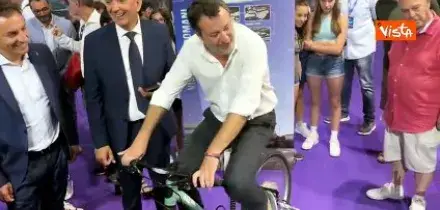 Salvini pedala una bicicletta che produce idrogeno al padiglione del Mit al Meeting di Rimini