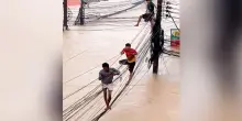 Alluvioni in Thailandia, persone si arrampicano sui cavi per sfuggire all’acqua