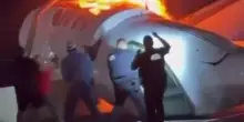 La carlinga dell'aereo in fiamme: gli automobilisti tentano di salvare i passeggeri