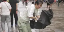 I forti venti del tifone Dolphin ribaltano gli ombrelli e sferzano residenti e turisti a Shanghai