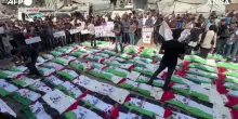 A Gaza funerale di massa per 100 vittime estratte dalle macerie: i corpi nelle bandiere palestinesi