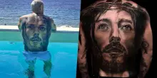 Calciatore al mare con Gesù Cristo tatuato su tutta la schiena: lo riconoscete?