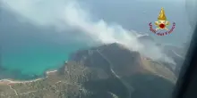 Sardegna, incendio vicino spiaggia. Bagnanti in fuga e auto distrutte