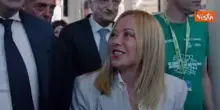 Meloni arriva al Meeting di Rimini accolta dagli applausi. Poi autografa il suo libro a un fan