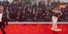 Venezia 82, una modella sfila sul red carpet con un abito decorato da un serpente dorato