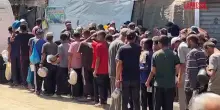 Gaza, decine di palestinesi in fila per un piatto di riso: le immagini da Deir Al-Balah