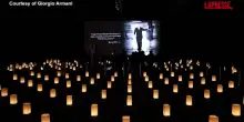 Armani, linterno della camera ardente al buio illuminata da candele