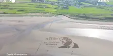 Disegnata su una spiaggia scozzese la maxi opera contro Trump: “È tempo di resistere” – Video