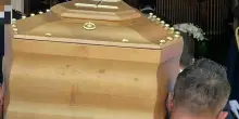 Bara si apre all'uscita della chiesa dopo il funerale: l'addetto dell'impresa funebre che inciampa e il corpo della defunta sotto il lenzuolo