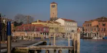 Ragazzi giocano a palla in campo veneziano, genitori in caserma
