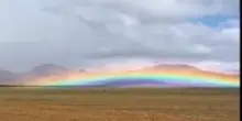 Tibet, l'arcobaleno sfiora le montagne: un turista immortala il fenomeo raro